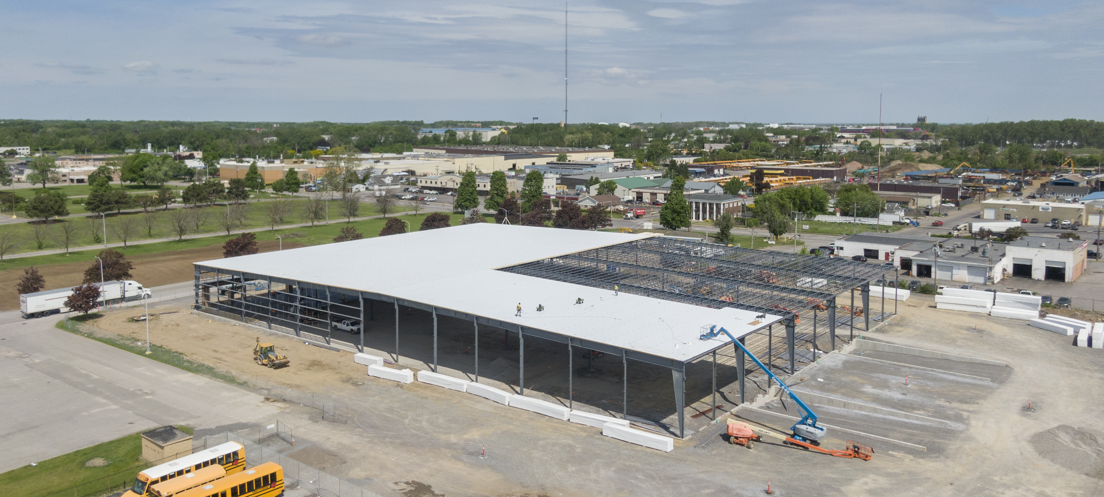 Photo of a OEM insulation being installed on roof of steel building